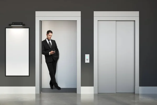 Man with smartphone in lift — Stock Photo, Image