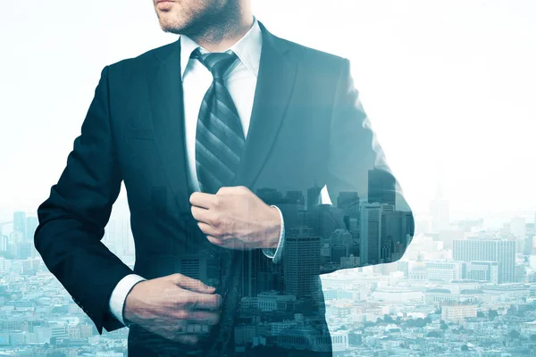 Thoughtful young businessman on creative city background with copy space. Career concept. Double exposure — Stock Photo, Image