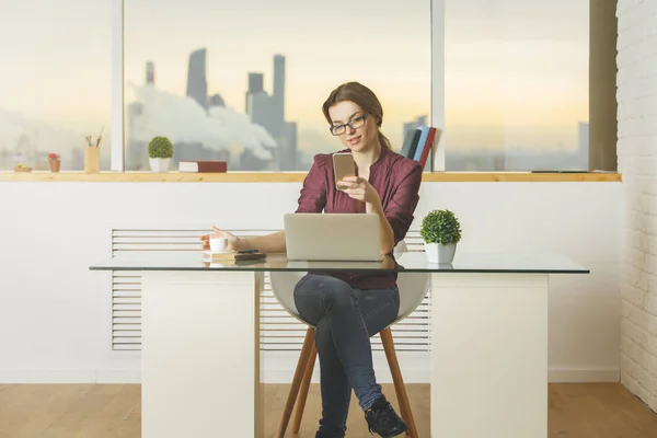 Mujer europea usando smartphone y portátil — Foto de Stock