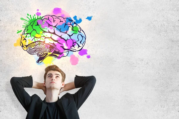 Retrato de atraente relaxante jovem europeu na parede de concreto baclground com esboço de negócios criativos. Conceito de brainstorm — Fotografia de Stock