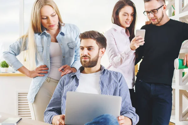 Çekici genç Avrupa grubu, iş erkek ve kadın modern ofis dizüstü, smartphone, evrak ve diğer öğeleri üstünde okul sırası ile proje üzerinde. Coworking kavramı 