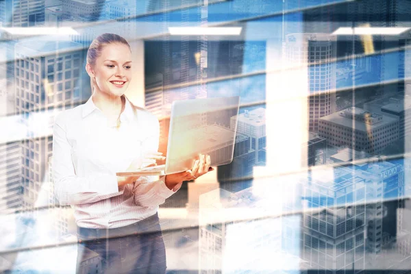 Cheerful young woman using laptop on abstract city background. Communication concept. Double exposure — Stock Photo, Image