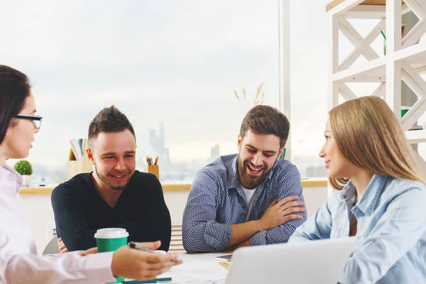 Çekici genç Avrupa grubu, iş erkek ve kadın modern ofis dizüstü, smartphone, evrak ve diğer öğeleri üstünde okul sırası ile proje üzerinde. Beraberlik kavramı 