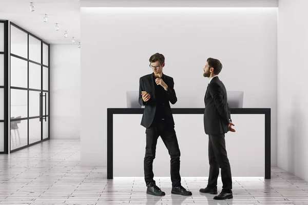 两个英俊的商人站在现代办公内政部与前台和玻璃门。会议概念。3d 渲染 — 图库照片