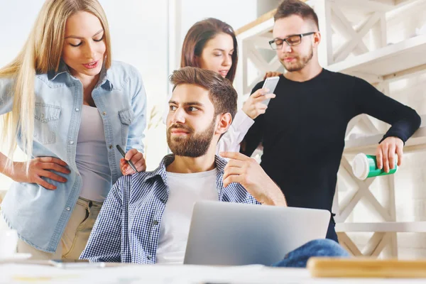 Attraktive junge europäische Gruppe, Geschäftsleute und -frauen, die an Projekten im modernen Büro mit Laptop, Smartphone, Papierkram und anderen Dingen auf dem Schreibtisch arbeiten. Modernes Konzept — Stockfoto