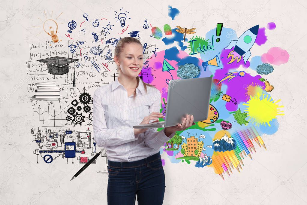 Smiling young businesswoman with laptop standing on concrete wall background with business sketch. Education concept