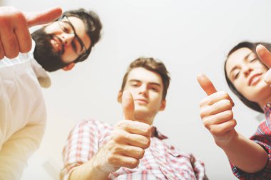 Başparmak ışık arka plan üzerinde gösterilen genç takımının alt görünümü. Başarı kavramı 