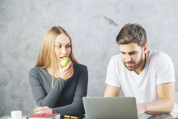 Pareja europea en el escritorio con ordenador portátil — Foto de Stock