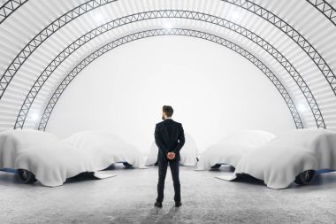 Düşünceli işadamı ile araba örtüsü altında Ambar iç. Gizli kavramı. 3D render 