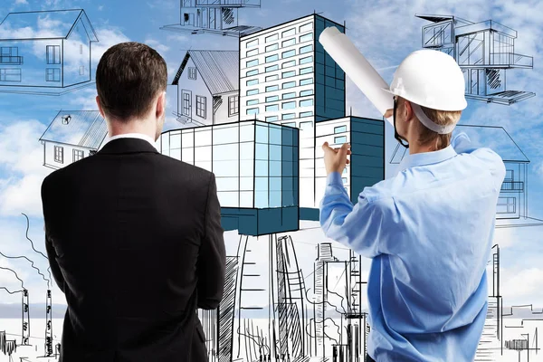 Back view of young businessman and engineer discussing project on sky background with drawn houses. Construction concept — Stock Photo, Image