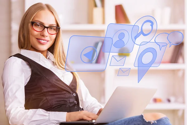 Sidovy av leende ung kvinna använder laptop med digitala media interface i suddiga office. Nätverk-konceptet — Stockfoto