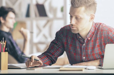 İşyerinde sarmal Defteri'nde yazma yakışıklı beyaz adam portresi. Evrak kavramı. İçinde belgili tanımlık geçmiş bulanık meslektaşım