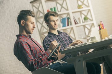 Projede işyerinde çalışan iki yakışıklı beyaz erkek portresi. Ekip çalışması kavramı