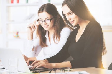 Çekici kadınlar işyerinde dizüstü bilgisayar kullanarak