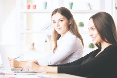 Güzel kadınlar işyerinde dizüstü bilgisayar kullanarak