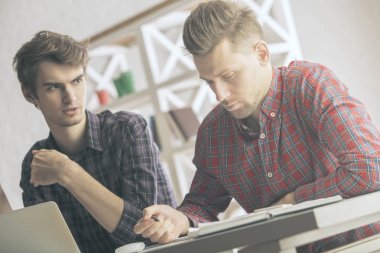 Portre iki beyaz erkek office masaüstü yerinde proje üzerinde duruldu. Ekip çalışması kavramı