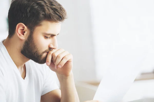 Homem atraente examinando lado documento — Fotografia de Stock