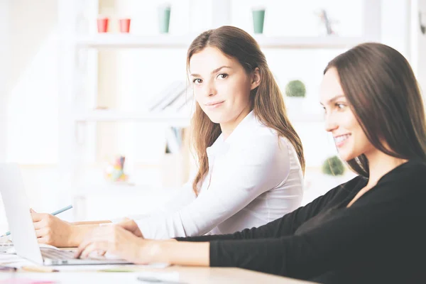 Mulheres lindas usando laptop no local de trabalho — Fotografia de Stock