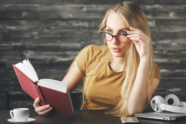 Düşünceli kadın masasında kitap okumak 