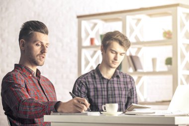 Projede işyerinde çalışan iki yakışıklı beyaz iş arkadaşları portresi. Ekip çalışması kavramı