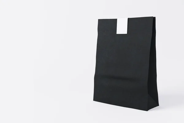 Bolsa de almuerzo de papel negro sellada sobre fondo claro. Concepto de contenedor. Maquillaje, renderizado 3D — Foto de Stock