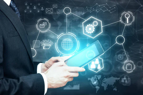 Genç işadamı soyut parlayan iş hologram kara tahta arka plan ile tablet kullanarak yan görünüm. Gelecekteki kavramı 