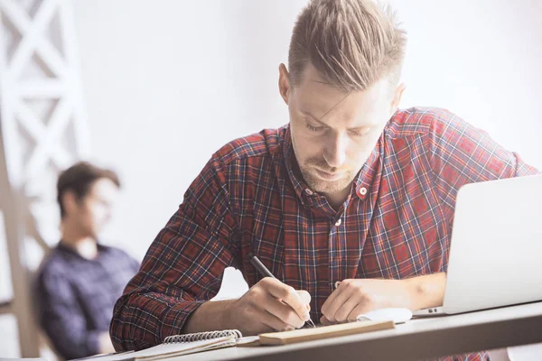 İşyerinde sarmal Defteri'nde yazma yakışıklı beyaz beyefendi portresi. Evrak kavramı. İçinde belgili tanımlık geçmiş bulanık meslektaşım