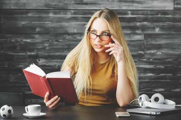 Güzel kadın masasında kitap okumak 