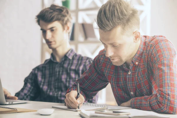 Projede işyerinde çalışan iki yakışıklı beyaz adam portresi. Ekip çalışması kavramı