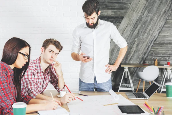 Evrak işlerini yapıyor ve aygıtlarını kullanarak düşünceli insanlar 