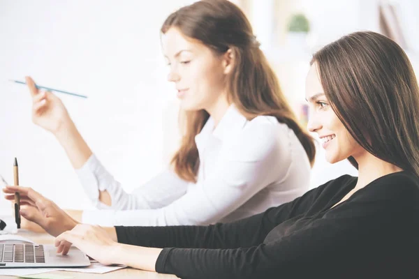 Atractivas mujeres de negocios que utilizan el ordenador portátil en el lugar de trabajo —  Fotos de Stock