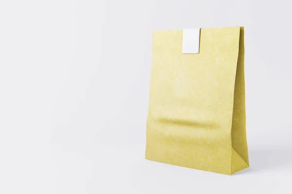 Bolsa de almuerzo de papel amarillo sellada sobre fondo claro. Concepto medioambiental. Maquillaje, renderizado 3D — Foto de Stock