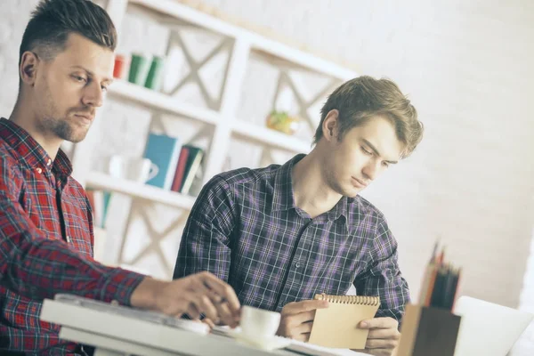 Retrato de dois bonitos empresários caucasianos que trabalham no projeto no local de trabalho. Conceito de trabalho em equipa — Fotografia de Stock