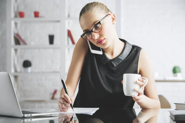 Mujer centrada en el teléfono haciendo papeleo — Foto de Stock