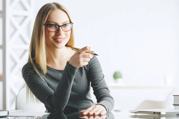 Mujer de negocios reflexiva señalando en el escritorio — Foto de Stock