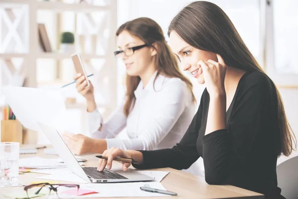 Las mujeres utilizando el ordenador portátil y smartphone — Foto de Stock