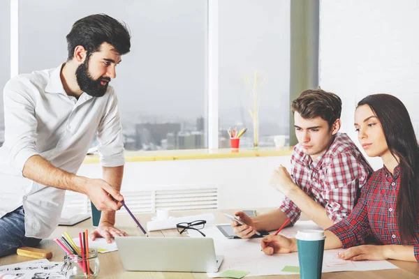 Attraktive Menschen, die Papierkram erledigen und Geräte nutzen — Stockfoto