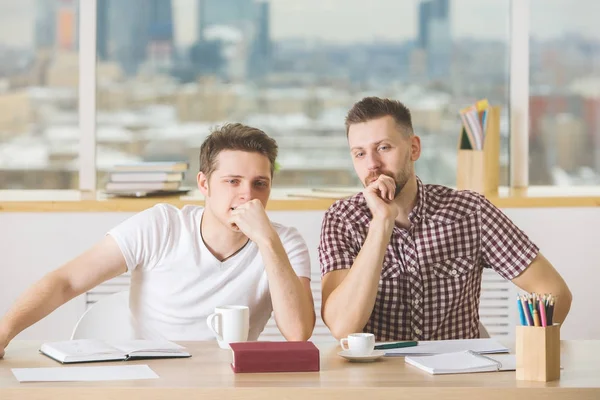 Hombres guapos leyendo libro y haciendo papeleo — Foto de Stock