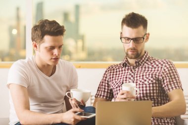 Yakışıklı erkekler laptop ve smartphone kullanarak