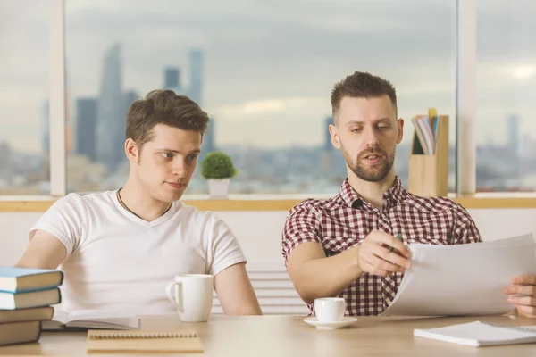 Hombres atractivos haciendo papeleo frente — Foto de Stock