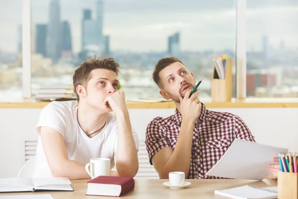 Chicos atractivos leyendo libro y haciendo papeleo — Foto de Stock