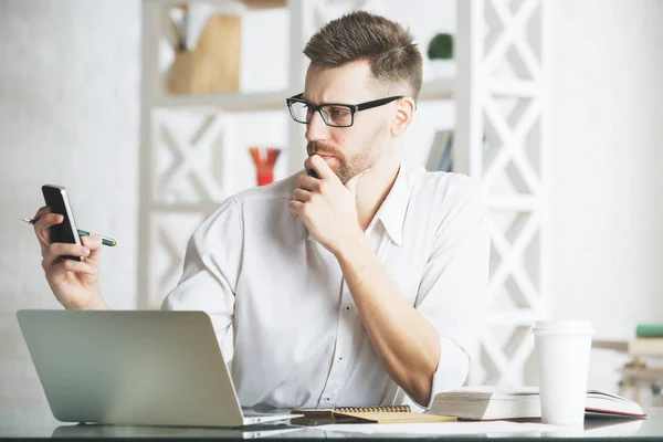 Handsome businessman using device at workplace