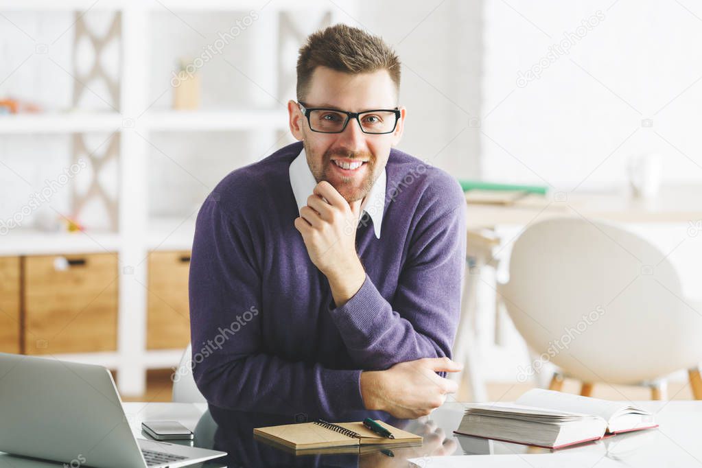 Attractive smiling businessman working on project 