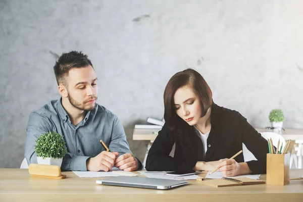 Caucásico hombre de negocios y mujer haciendo papeleo — Foto de Stock