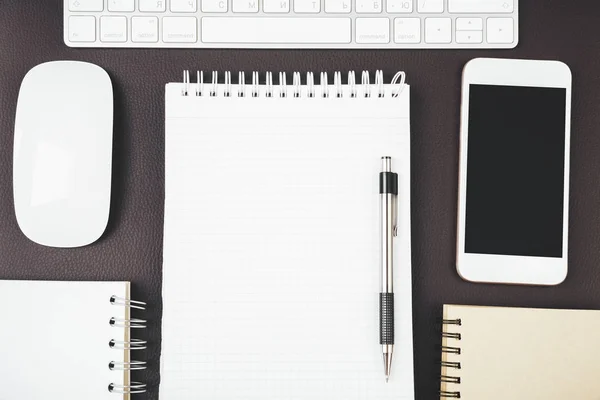 Modern desk top with empty smartphone and supplies — Stock Photo, Image