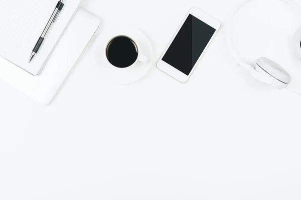 Mesa blanca creativa con teléfono móvil en blanco —  Fotos de Stock