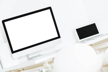 Temiz beyaz dizüstü bilgisayar, sarf malzemeleri ve diğer çeşitli nesneler ile modern tasarımcı masaüstü. Yakın çekim, yukarı alay