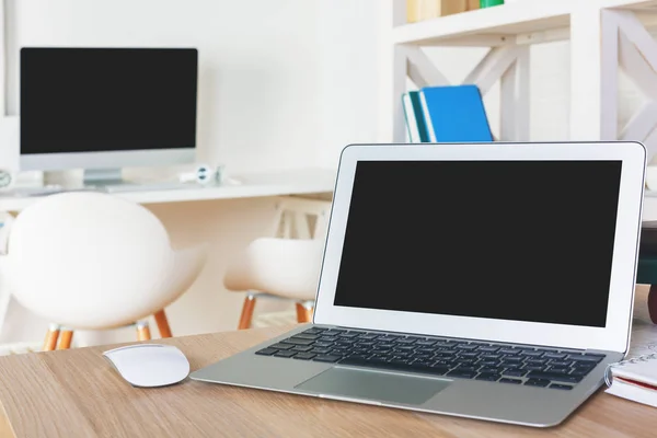 Designer desktop with empty laptop screen