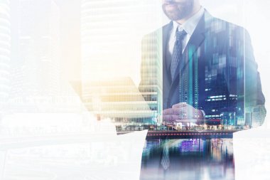 Şehir arka plan üzerinde dizüstü bilgisayar kullanan adam 