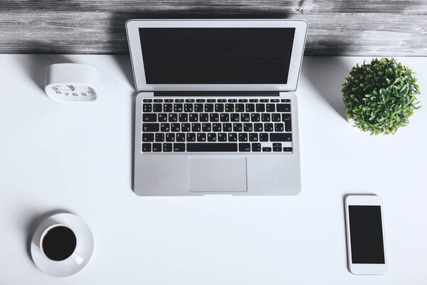 White desk with blank laptop